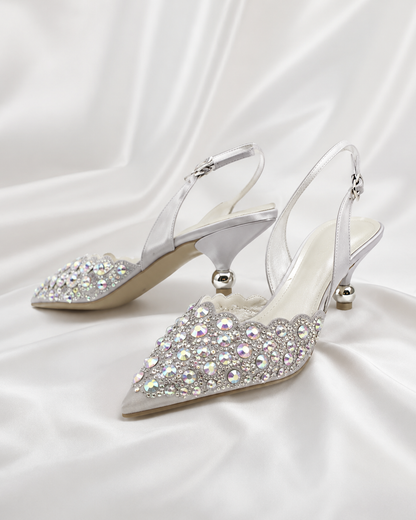 A pair of pointed-toe slingback high heels embellished with sparkling silver and iridescent rhinestones.