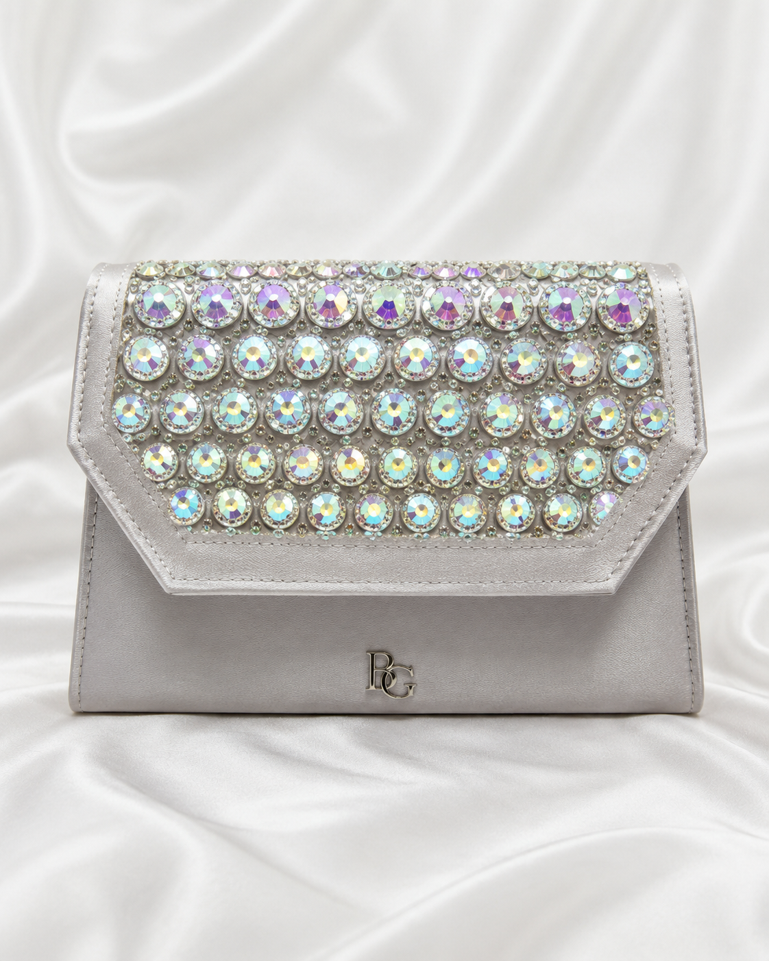 A silver clutch bag embellished with rows of iridescent round rhinestones across the front flap,