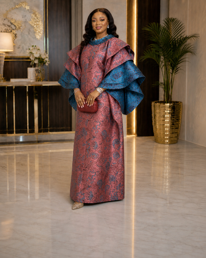 A luxurious rose-pink and teal African boubou featuring ornate pattern detailing, dramatic layered sleeves, and a flowing maxi silhouette. Perfect for weddings, birthdays, church, Eid, owambe parties, and elegant cultural celebrations.