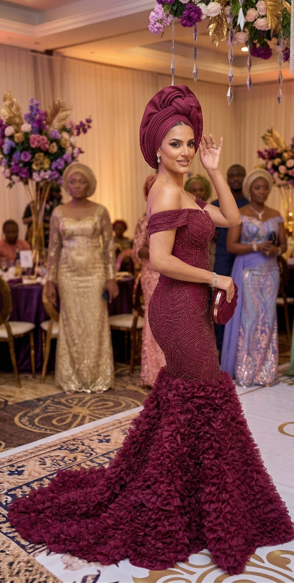 Woman in a burgundy off-shoulder gown with floral details at an event.